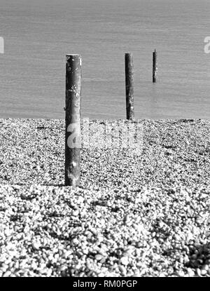 De pieux d'acier rouillé menant de la plage de galets de la mer à la baie de Sandwich, Kent, UK. Banque D'Images