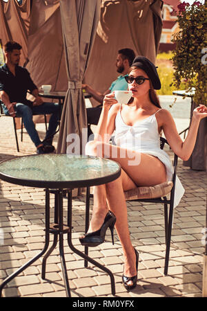 Commencez par sentir l'arôme avant dégustation. Jolie femme boire un café dans le café en plein air. Femme aime boire de l'espresso ou cappuccino. Adorable femme en Banque D'Images