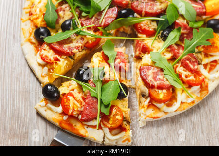 En tenant Tranche de pizza, fromage fondu s'égoutte Banque D'Images