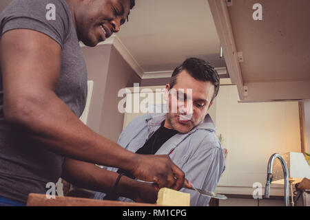 Un couple gay, partage les histoires de leur journée au travail sur une tranche de pain grillé et une tasse de thé et café dans la soirée. Banque D'Images