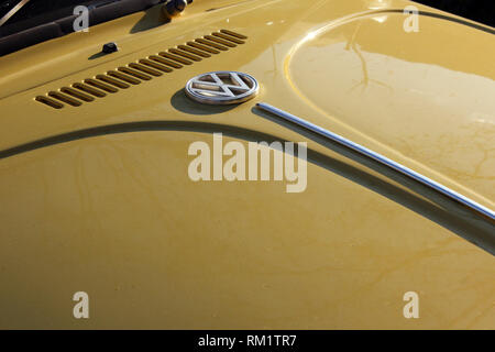 Ancien capot Volkswagen Beetle jaune avec logo marque, close-up Banque D'Images