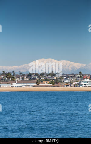 Newport Beach avec des paysages enneigés des montagnes San Gabriel dans l'arrière-plan d'un bateau d'observation des baleines. Orange County, Californie, USA. Banque D'Images