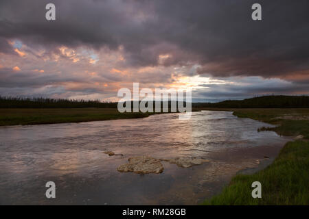 WY03473-00...WYOMING -Lever du soleil illuminant l'Gibbin River comme il coule à travers prés Gibbon dans le Parc National de Yellowstone. Banque D'Images