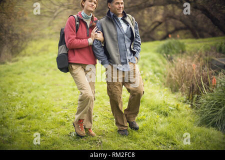 Mid-adult couple en train de marcher ensemble dans le domaine rural. Banque D'Images