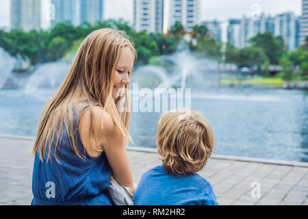 Maman heureuse avec petit-fils bénéficiant d'eau des fontaines Banque D'Images