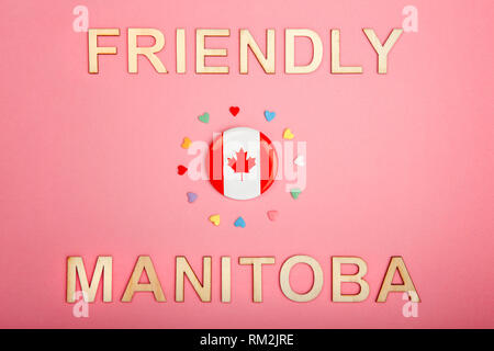 Bonne fête du Canada Carte postale avec des lettres en bois. Licence provinciale du Manitoba slogan disant wild rose country et drapeau du Canada avec beaucoup de cœurs sur Banque D'Images