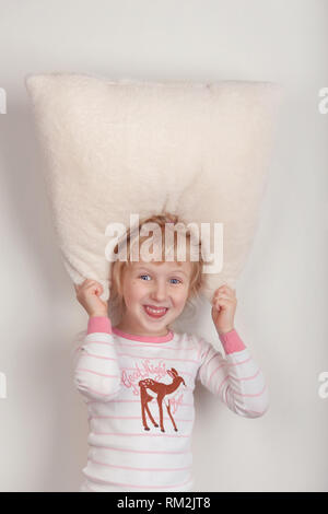 Pas d'insomnie sommeil concept. Funny Cute adorable blond excité surpris Caucasian girl enfant avec yeux grands ouverts jeu blanc moelleux doux pil Banque D'Images