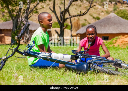 Harrismith (Afrique du Sud - 18 octobre 2012 : les enfants africains fixant une crevaison sur un vélo Banque D'Images