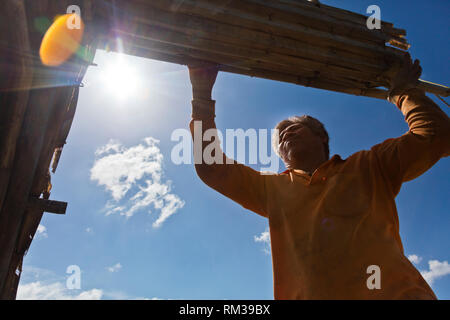 Un homme se range MOKEN son voile sur son bateau traditionnel à KHO RA Île dans la mer d'Andaman - Thailande Banque D'Images