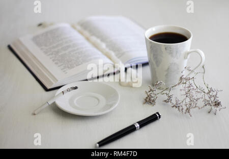 L'humeur du matin femme mains une tasse de café, un ordinateur portable et d'une cigarette sur une table en bois blanc Banque D'Images