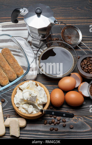 Ingrédients pour faire le gâteau tiramisu italien traditionnel sur table en bois Banque D'Images