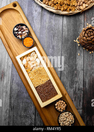 Jeu de collecte de céréales : lentilles rouges, haricots mungo, pois chiche, sarrasin, sur une table de cuisine en bois avec les graines de lin, graines de citrouille et le sésame, le cèdre Banque D'Images