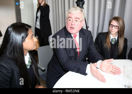 Un vice-Premier ministre irlandais Tánaiste, Eamon Gilmore chats aux étudiants (de gauche à droite) Béthanie Graham et Eimear Lawlor de la St Patrick, Belfast après un déjeuner-causerie marquant le 15ème anniversaire de la signature de l'Accord de Belfast, lundi 29 avril à la MAC. Le Tánaiste a rejoint le secrétaire d'État pour l'Irlande du très honorable Theresa Villiers MP lors de l'événement qui était remplie de jeunes nés en 1998, les jeunes et les organisations communautaires, les chefs d'entreprises et des universitaires. Photo/Paul McErlane Banque D'Images