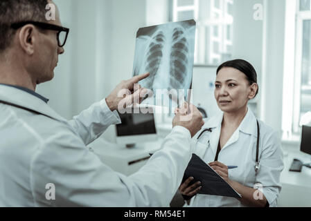 Intéressé traumatologist pointez sur l'x-ray photo Banque D'Images