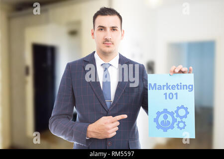 Homme portant costume et cravate montrant le marketing doit savoir des mécanisme et personne dessin sur papier bleu en tant que concept d'apprentissage Banque D'Images