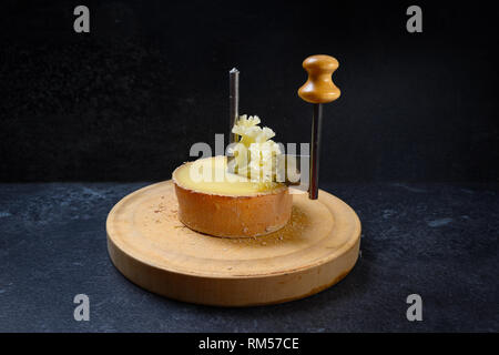 Girolle, un couteau spécial pour tête de moine du moine ou de couper le fromage en copeaux légers sous forme de rosettes, fond dark slate with copy space, séle Banque D'Images