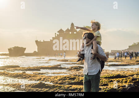 Père et fils les touristes sur l'arrière-plan de Tanah Lot - Temple dans l'océan. Bali, Indonésie. Voyager avec des enfants concept Banque D'Images