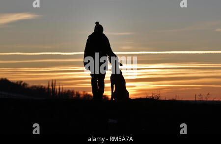 Toucher une photo d'un petit garçon et un chien de la race Berger Belge Malinois sur l'arrière-plan d'un beau coucher du soleil Banque D'Images