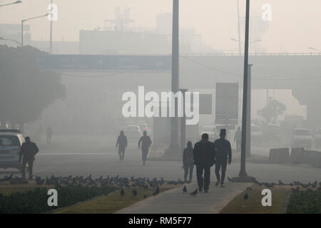Les piétons circulant dans des niveaux dangereux de pollution atmosphérique dans les Delhi Aerocity, New Delhi, Inde