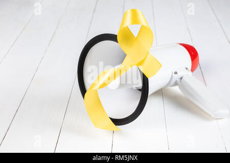 Ruban jaune couleur symbolique de Kaposi cancer des os et de sensibilisation sur la prévention du suicide bois vieilli avec mégaphone. Le cancer, la santé, l'aide, de soins, de soutien, d'espoir, de maladie, de soins de concept Banque D'Images