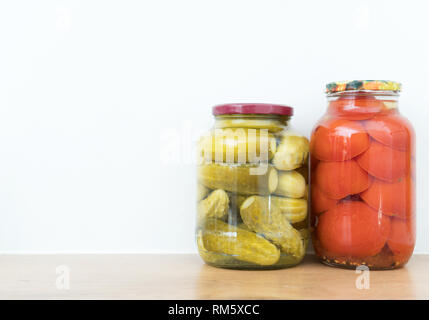 Concombres et tomates marinées dans des bocaux. L'espace pour le texte. Banque D'Images