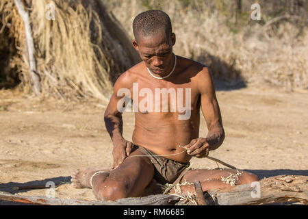 Un groupe de Bushmen la préparation des arcs et des flèches pour la chasse. Photographié en Namibie Banque D'Images