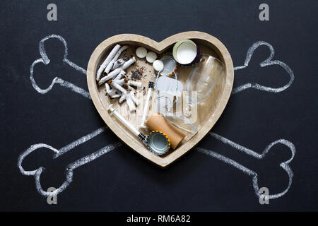Les substances addictives alcool cigarettes et les drogues dans le cœur et les os symbole de danger Banque D'Images