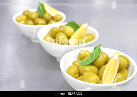 Bol en bois plein d'olives et les brindilles. Banque D'Images