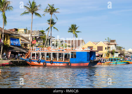Vue sur l'eau à sampans touristiques traditionnels bateaux amarrés le long de la rivière Thu Bon dans le vieux quartier de la ville historique. Hoi An, Quang Nam Province, Vietnam Banque D'Images