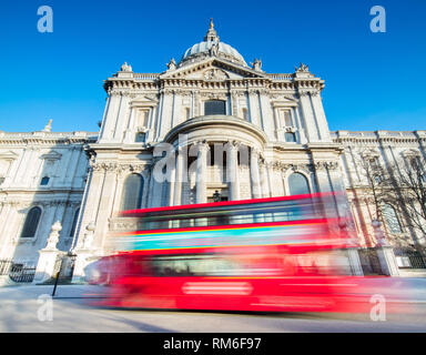 Un grand bus rouge en passant devant la Cathédrale St Paul à Londres. Banque D'Images