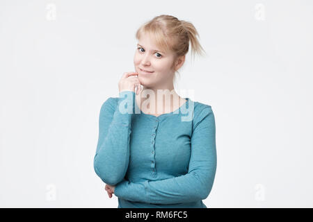 Jolie adolescente aux cheveux blonds, vêtu de façon décontractée, à la satisfaction de l'appareil photo à Banque D'Images