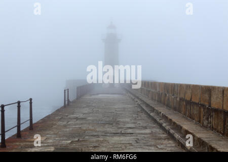 Vieux phare et de la jetée dans un matin brumeux Banque D'Images