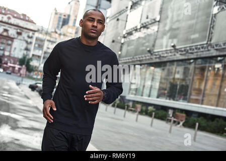 Bénéficiant d'un mode de vie sain. Close-up portrait of sporty young African man in sportswear à commencer ses exercices du matin dans la ville. Concept d'entraînement. Sport concept. Concept de santé Banque D'Images