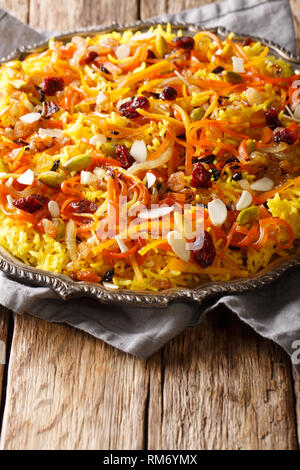 Jeweled iranien riz avec les fruits secs, les carottes, le zeste d'orange et les écrous libre sur une plaque sur la table verticale. Banque D'Images