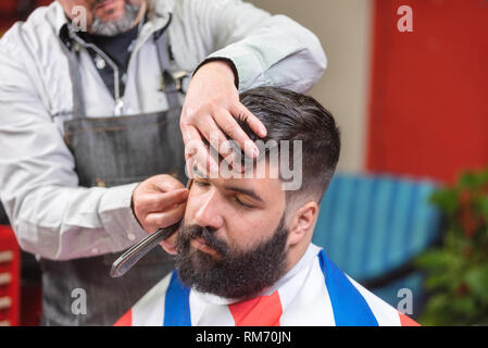 Beau barbu se coupe par coiffure au salon de coiffure . Banque D'Images