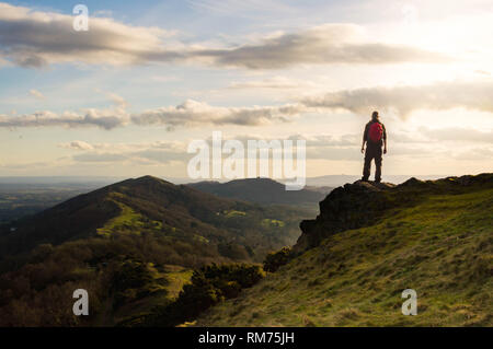 Un randonneur solitaire à l'ensemble de la crête des collines de Malvern sous le soleil d'hivers de l'après-midi. Le Malvern Hills, en Angleterre. Banque D'Images