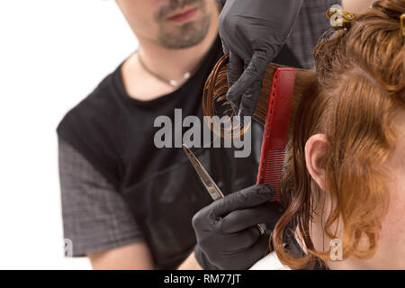 Coiffure tient entre les doigts mèche de cheveux avant de le couper. Libre Banque D'Images