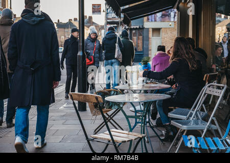 Londres, UK - Février 03, 2019 : Les gens assis à une table d'extérieur d'un café sur Broadway Market, une rue commerçante en plein cœur de Hackney, à l'Est Londo Banque D'Images