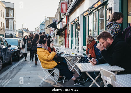 Londres, UK - Février 03, 2019 : Les gens assis à une table d'extérieur d'un café sur Broadway Market, une rue commerçante en plein cœur de Hackney, à l'Est Londo Banque D'Images