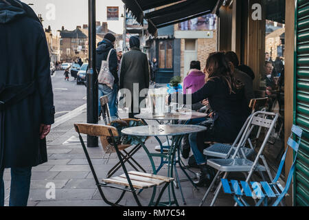 Londres, UK - Février 03, 2019 : Les gens assis à une table d'extérieur d'un café sur Broadway Market, une rue commerçante en plein cœur de Hackney, à l'Est Londo Banque D'Images