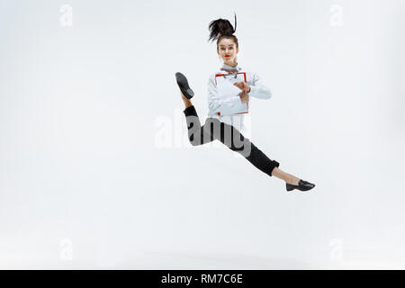 Happy businesswoman dancing and smiling in motion isolated on white background studio. La souplesse et la grâce dans les affaires. Les émotions humaines concept. Office de tourisme, la réussite professionnelle, le bonheur, les concepts d'expression, Banque D'Images