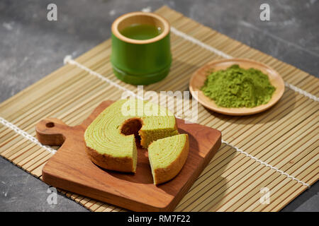Thé vert matcha latte dans une tasse et cérémonie du thé ustensiles avec gâteau allemand. Copy space Banque D'Images