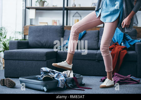 Portrait de femme en poussant les vêtements dans une valise à jambe après sa rupture avec petit ami Banque D'Images