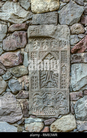 Khatchkar médiévale insérée dans le mur qui entoure le territoire de Guéghard monastère, situé dans les montagnes de Geghama ridge en Arménie Banque D'Images