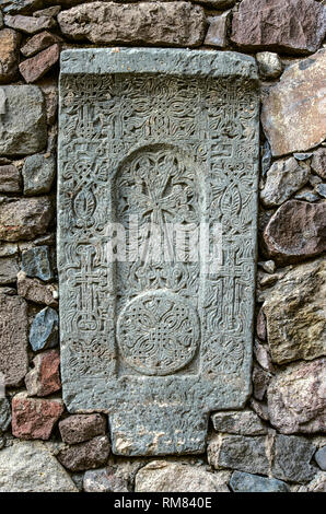 Khatchkar médiévale,inséré dans le mur, sur le territoire de l'Guéghard monastère, situé dans les montagnes de la chaîne de montagnes Geghama en Arménie Banque D'Images