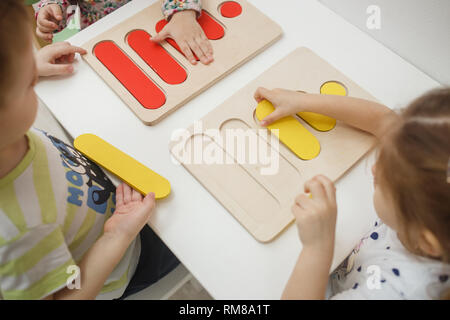 Les tout-petits jouer jeux éducatifs multicolores, mosaïque et casse-tête table. Banque D'Images