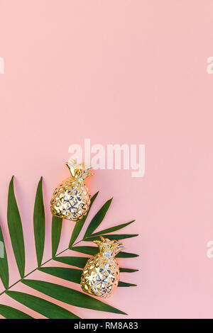 Télévision créative jeter Vue de dessus des feuilles de palmier tropical vert papier fond rose millénaire avec l'ananas copie espace. L'usine de feuille de palmier tropical minimal Banque D'Images