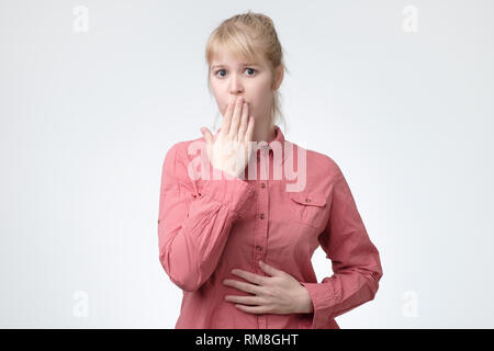 Choqué beautiful teenager girl wearing shirt couvrant sa bouche Banque D'Images