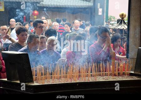 CANTON, Chine - Vers février 2018 : La foule de gens prier dans le temple taoïste pendant le Nouvel An chinois. Banque D'Images