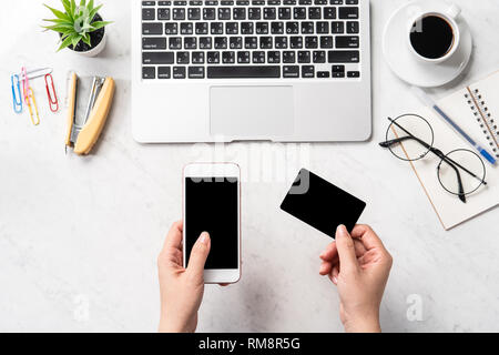 Une femme est en train de faire un achat en ligne, des maquettes et de carte de crédit sur téléphone cellulaire mobile office bureau isolé sur fond en mode copie, spac Banque D'Images